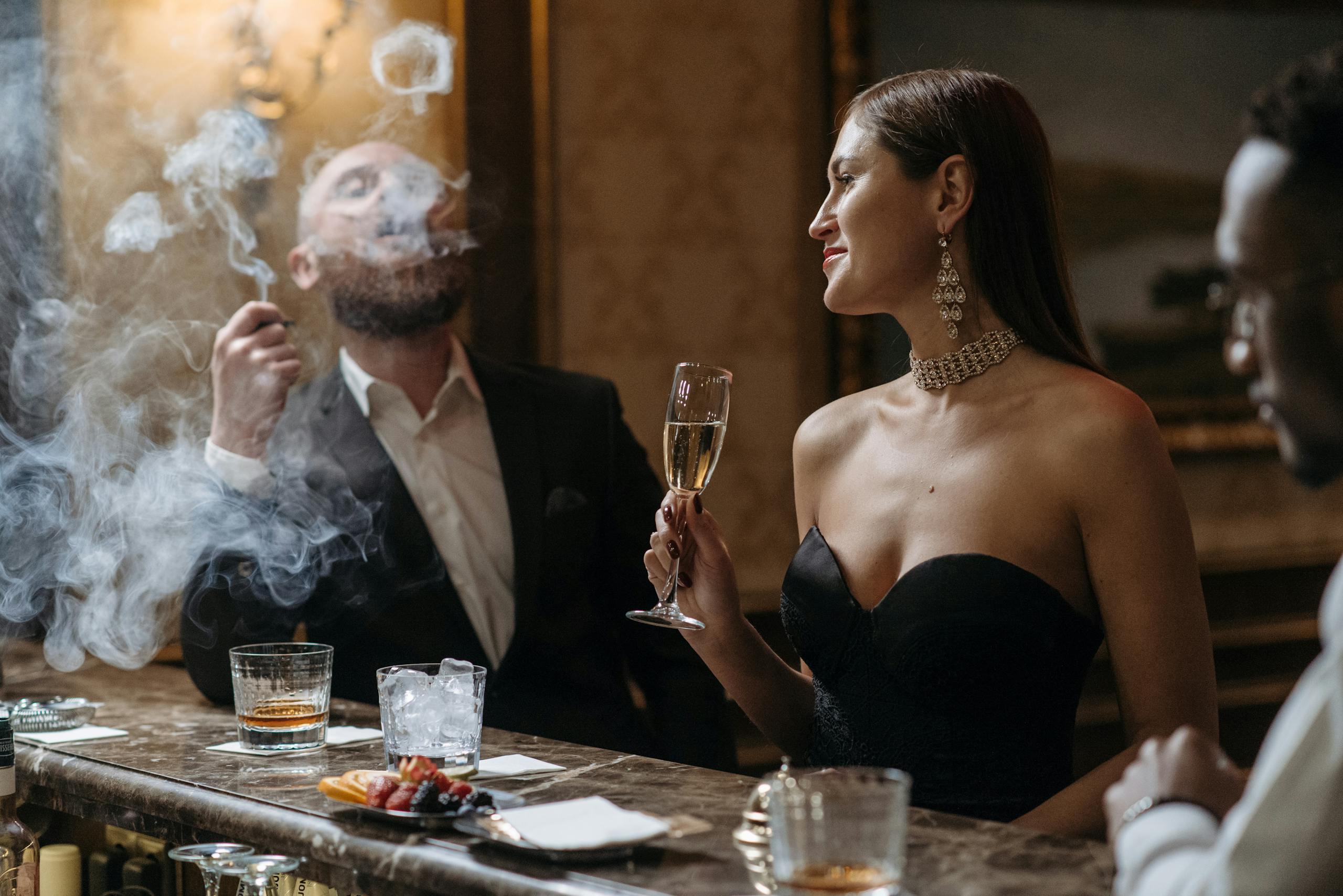 Sophisticated gathering at a bar with drinks and smoke, capturing elegance and leisure.